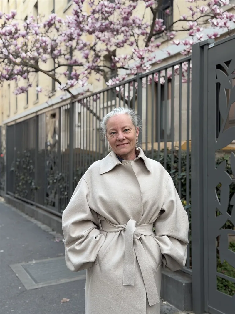 Cathrine Boye foran en blomstrende magnolie